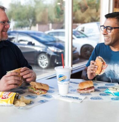 Two people enjoying lunch at a Port of Subs franchise location.